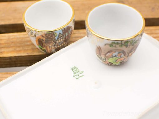 Charming artisan porcelain cups with cultural designs and elegant gold rims, perfect for collectors.