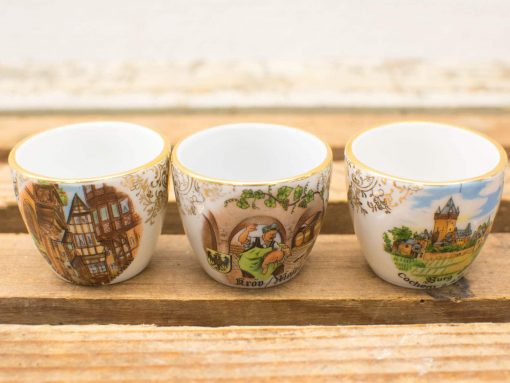 Charming vintage china cups with cultural designs and gold accents, perfect for collectors.