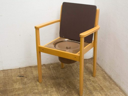 Dual-purpose wooden chair with hidden toilet feature, ideal for accessible care settings.
