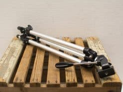 Compact aluminum tripod on rustic wooden pallet, ideal for photography and videography.