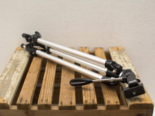 Compact aluminum tripod on rustic wooden pallet, ideal for photography and videography.