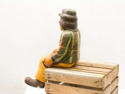 Colorful clown on a rustic crate, perfect for vintage decor and nostalgic charm.