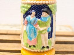 Charming ceramic stein featuring a traditional couple in vibrant colors, a perfect decorative piece.