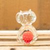 Playful glass owl figurine with a red polka-dotted ball, perfect for decor.