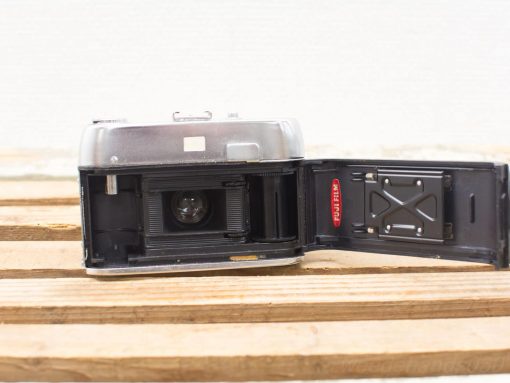 Vintage 1965 Halina Paulette camera with shiny metal finish and exposed mechanics.