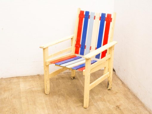 Vibrant red, white, and blue wooden chair, perfect for outdoor patio or garden use.