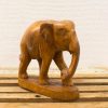 Intricately carved wooden elephant sculpture, showcasing expert craftsmanship and rich wood tones.