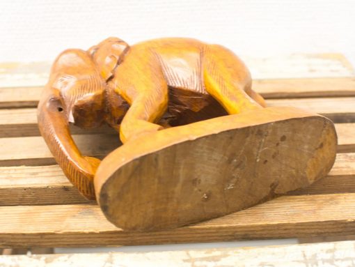 Handcrafted wooden elephant sculpture in playful pose, showcasing fine details and warm tones.