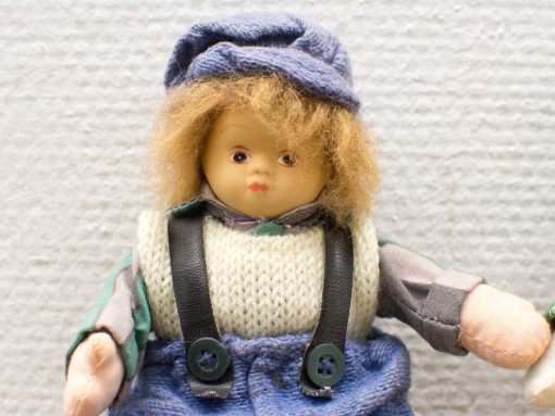 Charming vintage doll with playful attire and endearing features, perfect for collectors and nostalgia lovers.