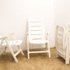 Versatile white plastic outdoor chairs for lounging and dining in a minimalist setting.