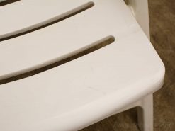 White slatted plastic chair, versatile seating for indoor and outdoor use.