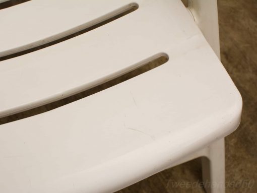 White slatted plastic chair, versatile seating for indoor and outdoor use.