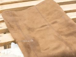 Luxurious brown suede on rustic wood, embodying vintage elegance and natural charm.