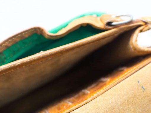 Chic light-brown leather handbag with vibrant green interior, perfect blend of style and functionality.