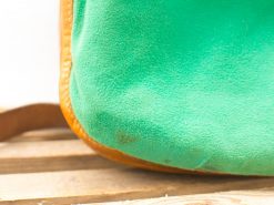 Bright green suede bag with warm leather trim, perfect for casual outings.