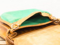 Chic vintage leather handbag with vibrant green lining and elegant detailing, perfect for any occasion.