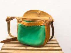 Vintage green handbag with leather accents, structured design, and adjustable strap for versatility.