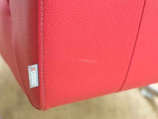 Vibrant red leather chair with textured surface and stylish stitching for modern interiors.
