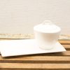 Elegant white porcelain sugar pot and plate set for refined dining occasions.