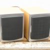 Modern wooden speakers with black grills, perfect for stylish home audio setups.