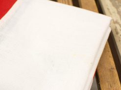 Elegant red and white fabrics on rustic wood, creating a cozy, inviting atmosphere.