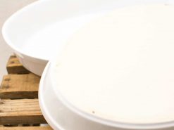 Elegant white ceramic serving dishes on a rustic wooden pallet, perfect for any dining occasion.