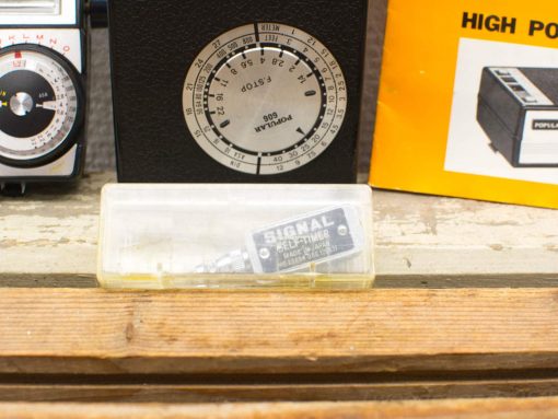 Explore classic vintage photography accessories, including a camera, light meter, and self-timer device.