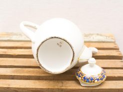 Elegant vintage porcelain teapot with decorative lid and intricate blue and gold patterns.
