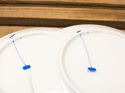 Elegant white plates on a rustic wooden table, featuring intriguing blue markings beneath.