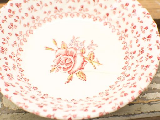 Vintage ceramic plate with a rose design, perfect for decor or dining elegance.