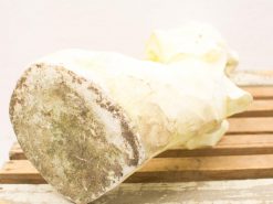 Elegant vintage stone sculpture with organic form, resting on a textured wooden surface.