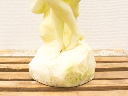 Elegant stone sculpture of intertwined women in a graceful dance, showcasing timeless beauty.