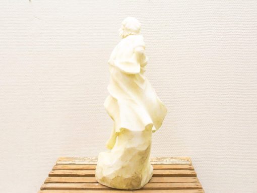 Unfinished female sculpture in motion, embodying elegance with flowing drapery and creamy tones.