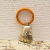 Vintage orange-brown keychain with a charming silver bell, perfect for nostalgic collectors.