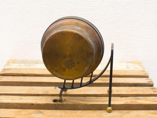 Vintage brass kettle on a sleek black stand, showcasing elegant craftsmanship and timeless charm.