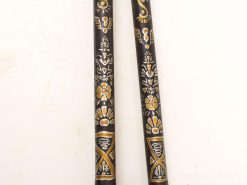 Elegant wooden sticks adorned with intricate white and gold designs, showcasing artistic cultural heritage.