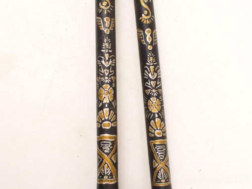 Elegant wooden sticks adorned with intricate white and gold designs, showcasing artistic cultural heritage.