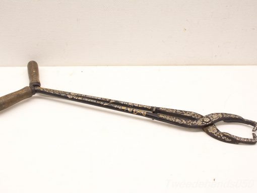 Antique-style tongs with intricate metalwork and a wooden grip, perfect for functional and decorative use.