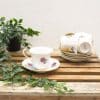 Elegant vintage teacup and saucer with floral motifs and greenery for a cozy tea time.