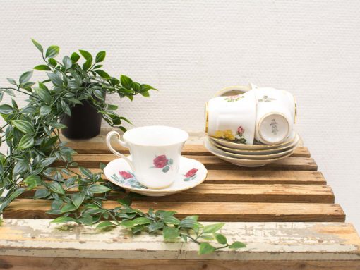 Elegant vintage teacup and saucer with floral motifs and greenery for a cozy tea time.