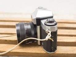 Vintage Praktica Nova IB camera on wooden surface, showcasing classic design and nostalgic charm.