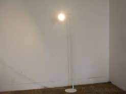 Sleek white floor lamp emitting warm light, perfect for modern interiors and cozy atmospheres.