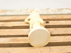 Stylized female sculpture on rustic wooden surface, showcasing fine craftsmanship and elegant design.