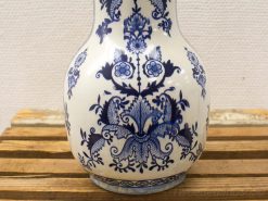 Elegant hand-painted blue floral ceramic vase on rustic wood surface.