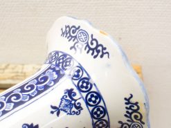 Intricately designed blue-and-white ceramic vase with scalloped rim and floral motifs.