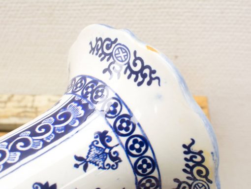 Intricately designed blue-and-white ceramic vase with scalloped rim and floral motifs.