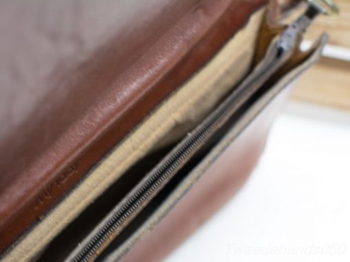 High-quality cognac leather shoulder bag with organized compartments and durable zippers.