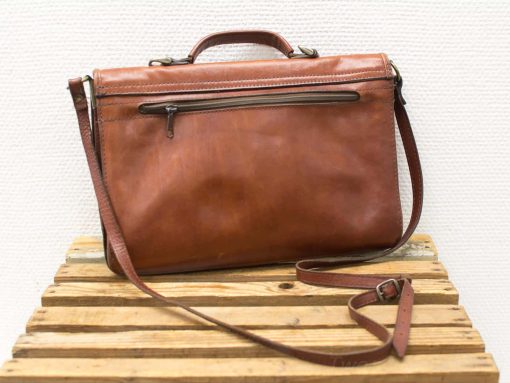 Stylish cognac leather handbag with adjustable strap and practical zipper pocket for everyday elegance.
