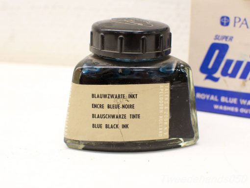 Vintage blue-black ink bottle with multilingual label, perfect for collectors and writing enthusiasts.