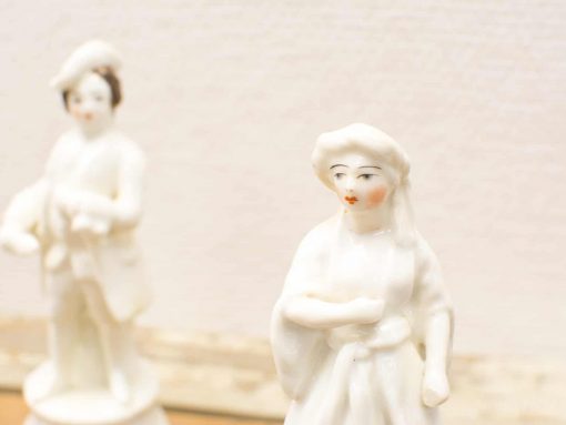 Elegant porcelain couple figurines showcasing fine craftsmanship and detailed artistry.